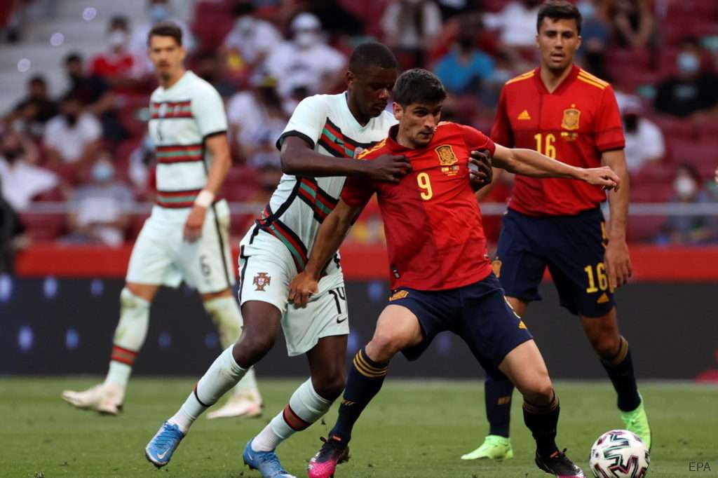 Spain forward Gerard Moreno holds off Portugal's William Carvalho