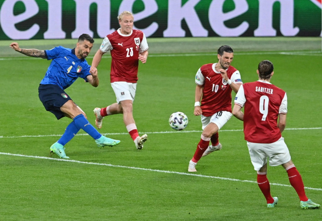 Leonardo Spinazzola (L) of Italy takes a shot at goal during the UEFA EURO 2020 round of 16 clash against Austria
