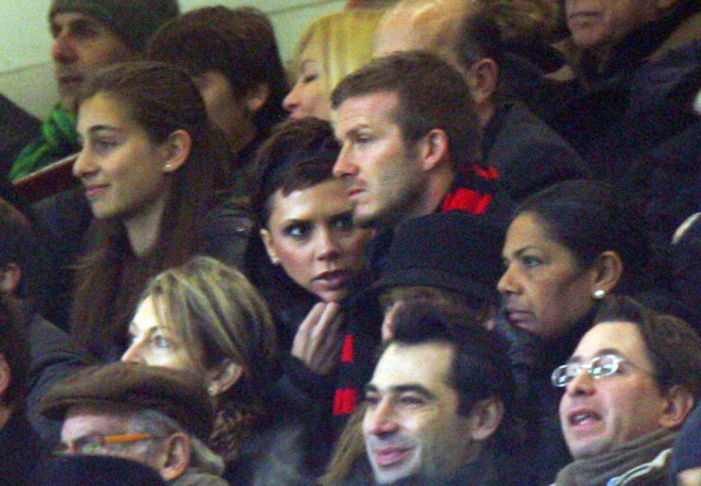 English midfielder David Beckham (C-R) wears an AC Milan scarf as he sits next to his wife Victoria (C-L, party obscured) in the central stand of Milan's San Siro-Giuseppe Meazza stadium to see the Italian Serie A soccer match AC Milan vs Udinese late 21 December 2008. Beckham was presented as the new AC Milan player on 20 December. EPA/MATTEO BAZZI