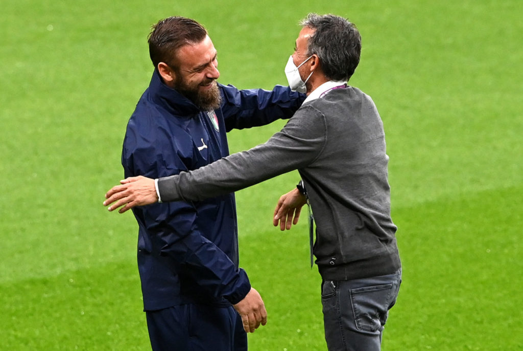 Daniele De Rossi (L), member of the Italian team's coaching staff, and Spain's head coach Luis Enrique meet on the pitch before the UEFA EURO 2020 semi final between Italy and Spain in London.