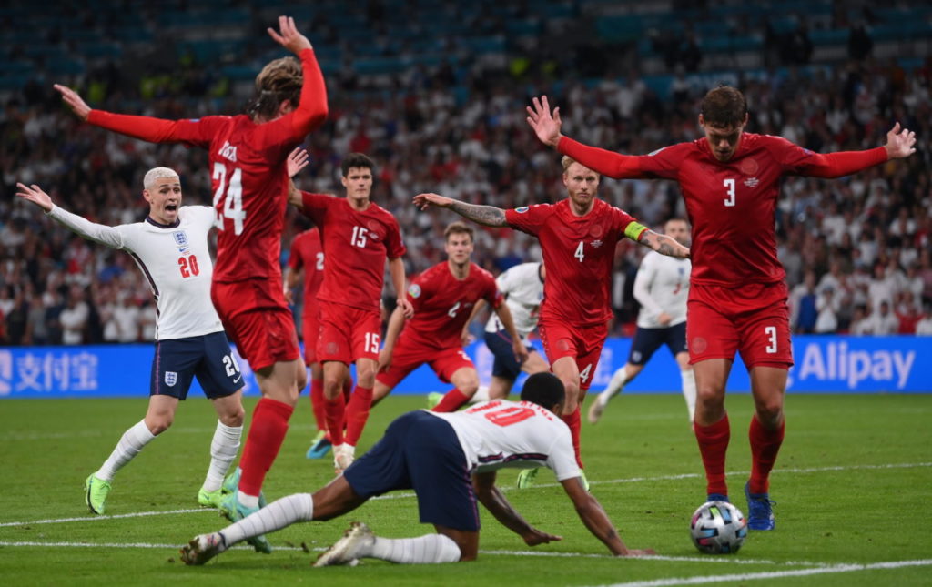 Raheem Sterling (down) of England is fouled in the penalty box during the UEFA EURO 2020 semi final between England and Denmark in London.