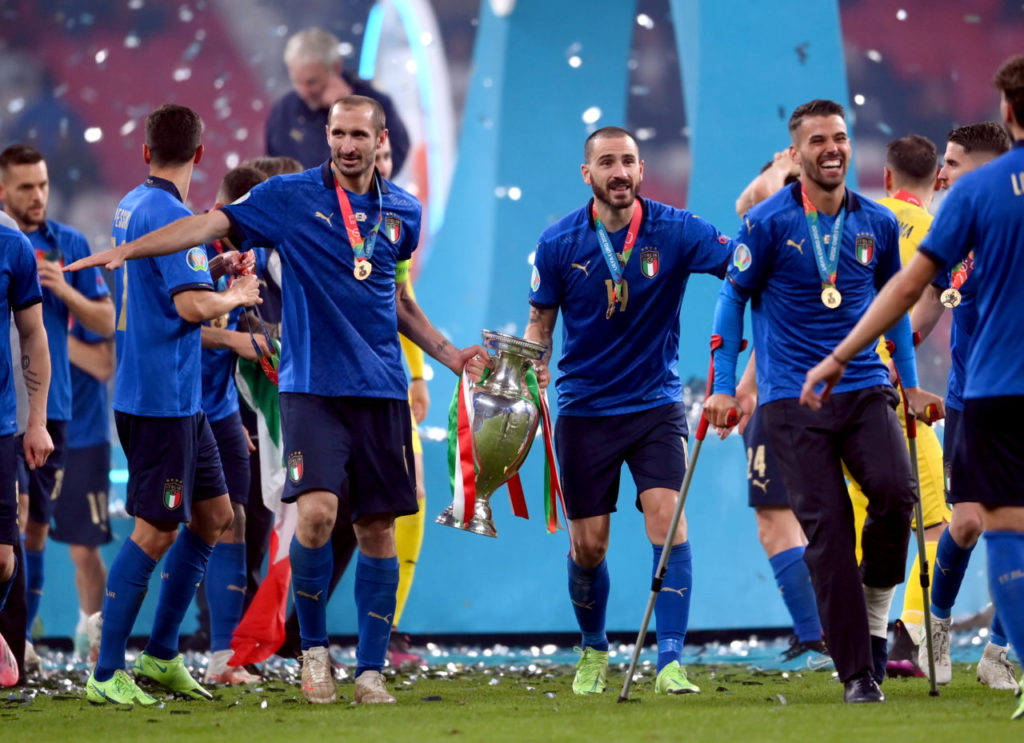 Leonardo Bonucci (CR), Giorgio Chiellini of Italy (CL) celebrate with the trophy and teammates after winning the UEFA EURO 2020 final between Italy and England in London.