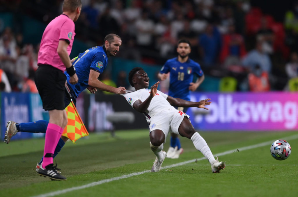 epa09338662 Giorgio Chiellini of Italy (L) fouls Bukayo Saka of England during the UEFA EURO 2020 final between Italy and England in London, Britain, 11 July 2021. EPA-EFE/Laurence Griffiths / POOL (RESTRICTIONS: For editorial news reporting purposes only. Images must appear as still images and must not emulate match action video footage. Photographs published in online publications shall have an interval of at least 20 seconds between the posting.)