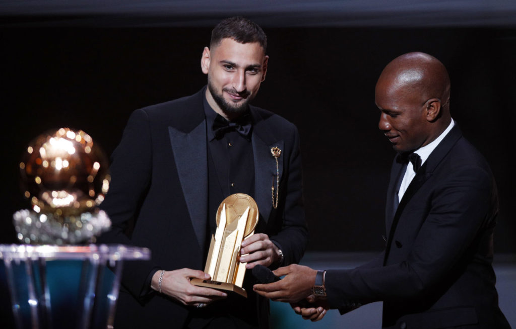 epa09611625 Host and former Chelsea striker Didier Drogba (R) hands PSG goalkeeper Gianluigi Donnarumma the 2021 Yashin Trophy as best goalkeeper the during the 2021 Ballon d'Or ceremony at Theatre du Chatelet in Paris, France, 29 November 2021. EPA-EFE/YOAN VALAT