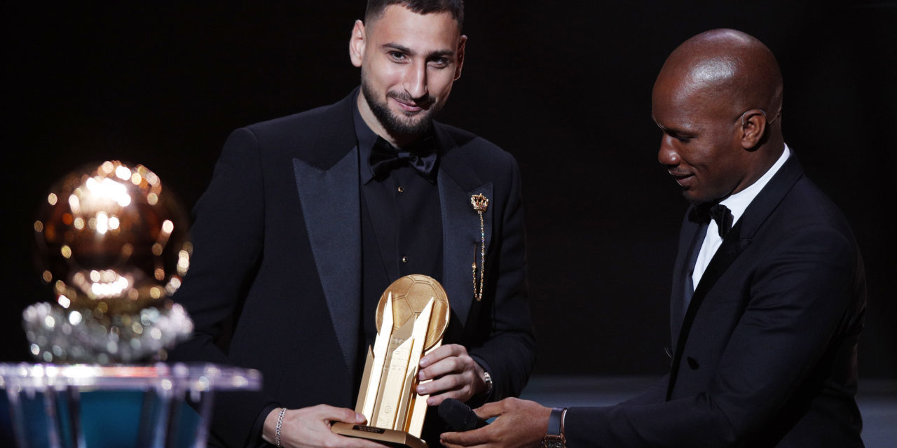 epa09611625 Host and former Chelsea striker Didier Drogba (R) hands PSG goalkeeper Gianluigi Donnarumma the 2021 Yashin Trophy as best goalkeeper the during the 2021 Ballon d'Or ceremony at Theatre du Chatelet in Paris, France, 29 November 2021. EPA-EFE/YOAN VALAT