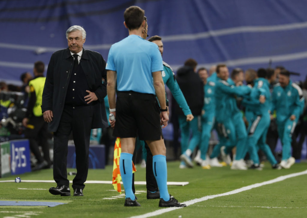 epa09927193 Real Madrid's head coach Carlo Ancelotti (L) reacts as players (back) celebrate the 2-1 goal during the UEFA Champions League semifinals' second leg soccer match between Real Madrid and Manchester City held at Santiago Bernabeu Stadium, in Madrid, Spain, 04 May 2022. EPA-EFE/BALLESTEROS
