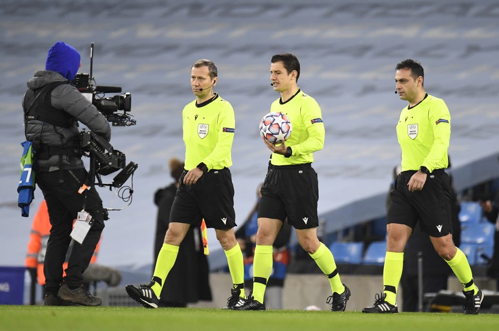 epa08873218 Match referee Halil Umut Meler (C) and assistants Mustafa Emre Eyisoy (L) and Cevdet Komurcuoglu (R) during the UEFA Champions League group C soccer match between Manchester City and Olympique Marseille in Manchester, Britain, 09 December 2020. EPA-EFE/Peter Powell / POOL