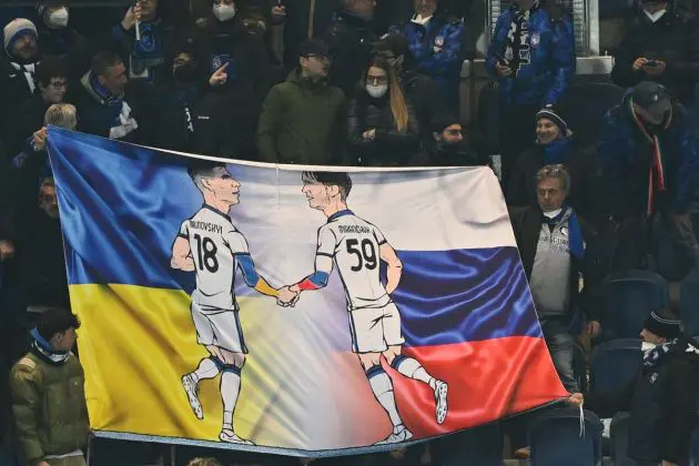 A fan's banner shows a figure of Atalanta midfielder Ruslan Malinovskyi (L) and Atalanta midfielder Aleksey Miranchuk shake hands, against Ukraine's flag (L) and Russia's flag, during the UEFA Europa League round of 16, 1st leg football match between Atalanta and Leverkusen on March 10, 2022 at the Azzurri d'Italia stadium in Bergamo. (Photo by MIGUEL MEDINA / AFP) (Photo by MIGUEL MEDINA/AFP via Getty Images)