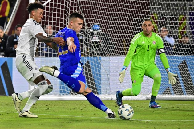 Argentina forward Lautaro Martinez (C) kicks the ball and scores his team's third goal as Costa Rica's goalkeeper #01 Keylor Navas looks on during the international friendly football match between Argentina and Costa Rica at LA Memorial Coliseum in Los Angeles on March 26, 2024. (Photo by Frederic J. BROWN / AFP) (Photo by FREDERIC J. BROWN/AFP via Getty Images)