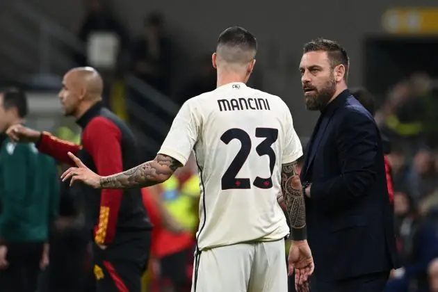 Roma's Italian defender #23 Gianluca Mancini speaks to Roma's Italian coach Daniele De Rossi during the UEFA Europa League football match between AC Milan and AS Roma at San Siro Stadium, in Milan on April 11, 2024. (Photo by Isabella BONOTTO / AFP) (Photo by ISABELLA BONOTTO/AFP via Getty Images)