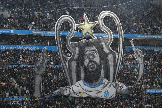 Inter support Marseille - TOPSHOT - A tifo depicting French-Algerian comedian Redouane Bougheraba and the Champions League trophy is displayed by Marseille supporters prior to the French L1 football match between Olympique Marseille (OM) and Paris Saint-Germain (PSG) at Stade Velodrome in Marseille, southeastern France, on March 31, 2024. (Photo by NICOLAS TUCAT / AFP) (Photo by NICOLAS TUCAT/AFP via Getty Images)