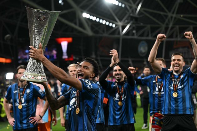 Atalanta's Brazilian midfielder #13 Ederson holds up the trophy as Atalanta's players celebrate after the UEFA Europa League final football match between Atalanta and Bayer Leverkusen at the Dublin Arena stadium, in Dublin, on May 22, 2024. Atalanta won the game 3-0. (Photo by Paul ELLIS / AFP) (Photo by PAUL ELLIS/AFP via Getty Images)