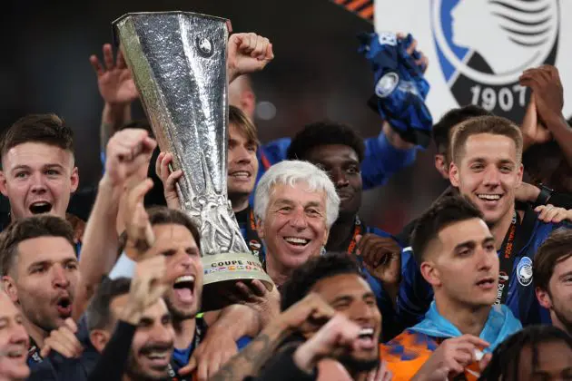 Atalanta's Italian coach Gian Piero Gasperini (C) and Atalanta's players celebrate with the trophy on the podium after winning the UEFA Europa League final football match between Atalanta and Bayer Leverkusen at the Dublin Arena stadium, in Dublin, on May 22, 2024. (Photo by Adrian DENNIS / AFP) (Photo by ADRIAN DENNIS/AFP via Getty Images)