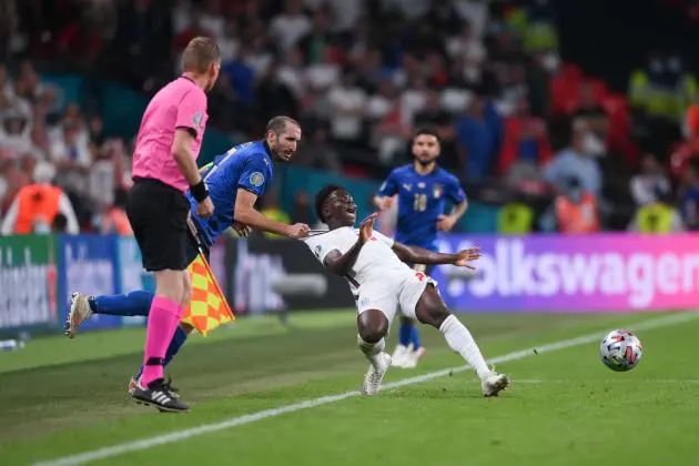 LONDON, ENGLAND - JULY 11: Bukayo Saka of England is fouled by Giorgio Chiellini of Italy during the UEFA Euro 2020 Championship Final between Italy and England at Wembley Stadium on July 11, 2021 in London, England. (Photo by Laurence Griffiths/Getty Images)