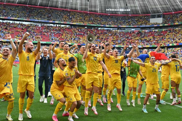 TOPSHOT - Romania players acknowledge the public as they celebrate at the end of the UEFA Euro 2024 Group E football match between Romania and Ukraine at the Munich Football Arena in Munich on June 17, 2024. (Photo by MIGUEL MEDINA / AFP) (Photo by MIGUEL MEDINA/AFP via Getty Images)