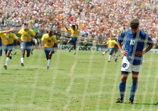 LOS ANGELES, UNITED STATES: Brazilian players run to join their teammates as Italian midfielder Roberto Baggio bows his head after he missed his penalty kick giving Brazil a 3-2 victory in the shoot-out session (0-0 after extra time) at the end of the World Cup final, 17 July 1994 at the Rose Bowl in Pasadena. Brazil won its fourth World Cup title after 1958, 1962 and 1970. AFP PHOTO/OMAR TORRES (Photo credit should read OMAR TORRES/AFP via Getty Images)