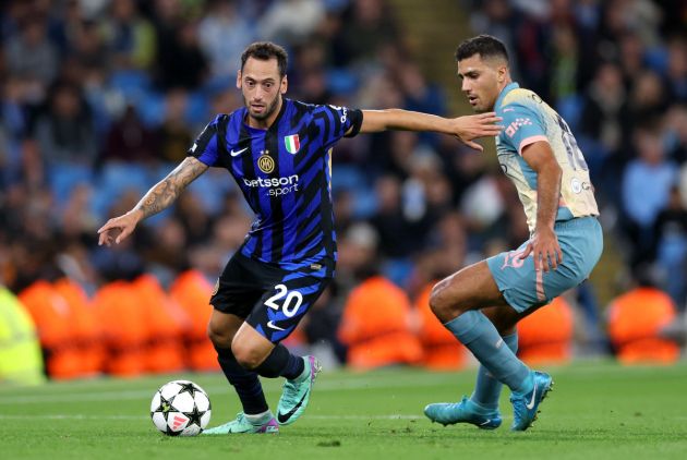 MANCHESTER, ENGLAND - SEPTEMBER 18: Hakan Calhanoglu of FC Internazionale runs with the ball under pressure from Rodri of Manchester City during the UEFA Champions League 2024/25 League Phase MD1 match between Manchester City and FC Internazionale Milano at City of Manchester Stadium on September 18, 2024 in Manchester, England. (Photo by Carl Recine/Getty Images)