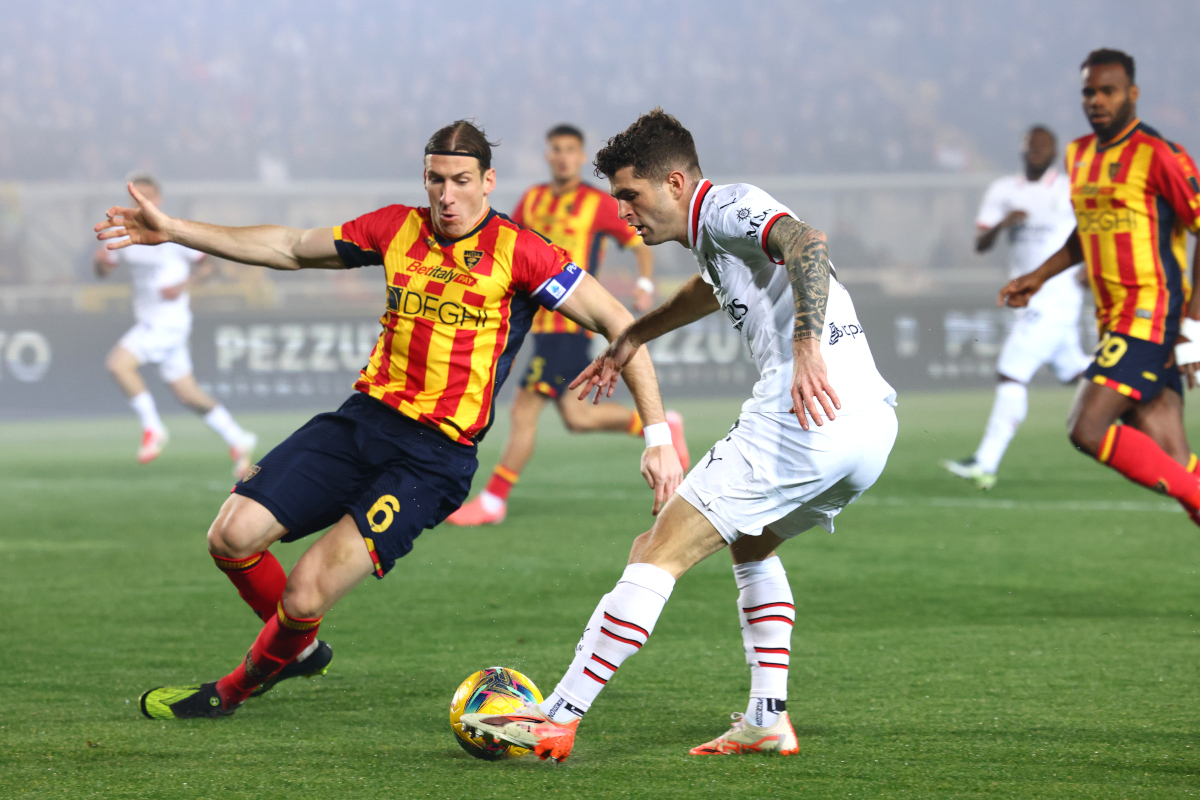 LECCE, ITALY - MARCH 08: Federico Baschirotto of Lecce competes for the ball with Christian Pulisic of Milan during the Serie A match between Lecce and AC Milan at Stadio Via del Mare on March 08, 2025 in Lecce, Italy. (Photo by Maurizio Lagana/Getty Images)