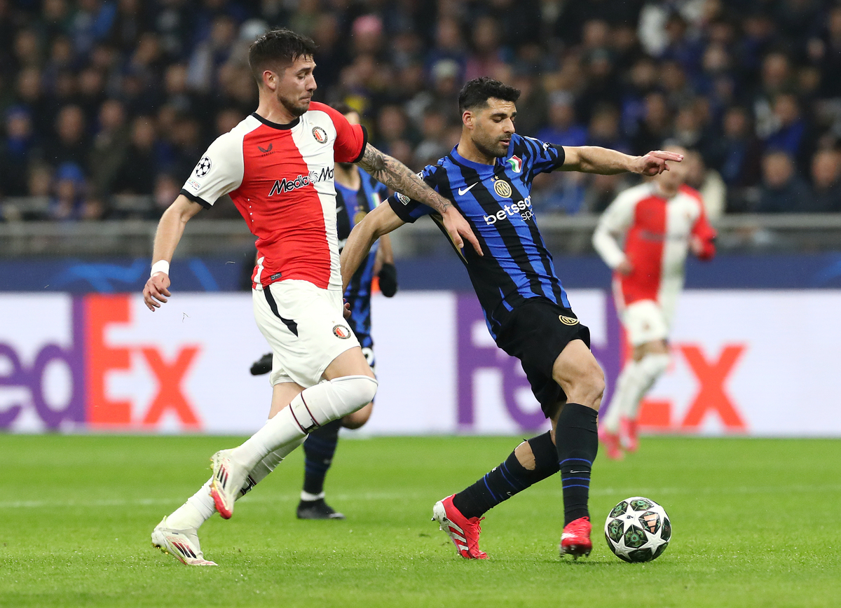MILAN, ITALY - MARCH 11: Mehdi Taremi of FC Internazionale (R) holds off the challenge of Jakub Moder of Feyenoord during the UEFA Champions League 2024/25 Round of 16 Second Leg match between FC Internazionale Milano and Feyenoord at Stadio San Siro on March 11, 2025 in Milan, Italy. (Photo by Marco Luzzani/Getty Images)