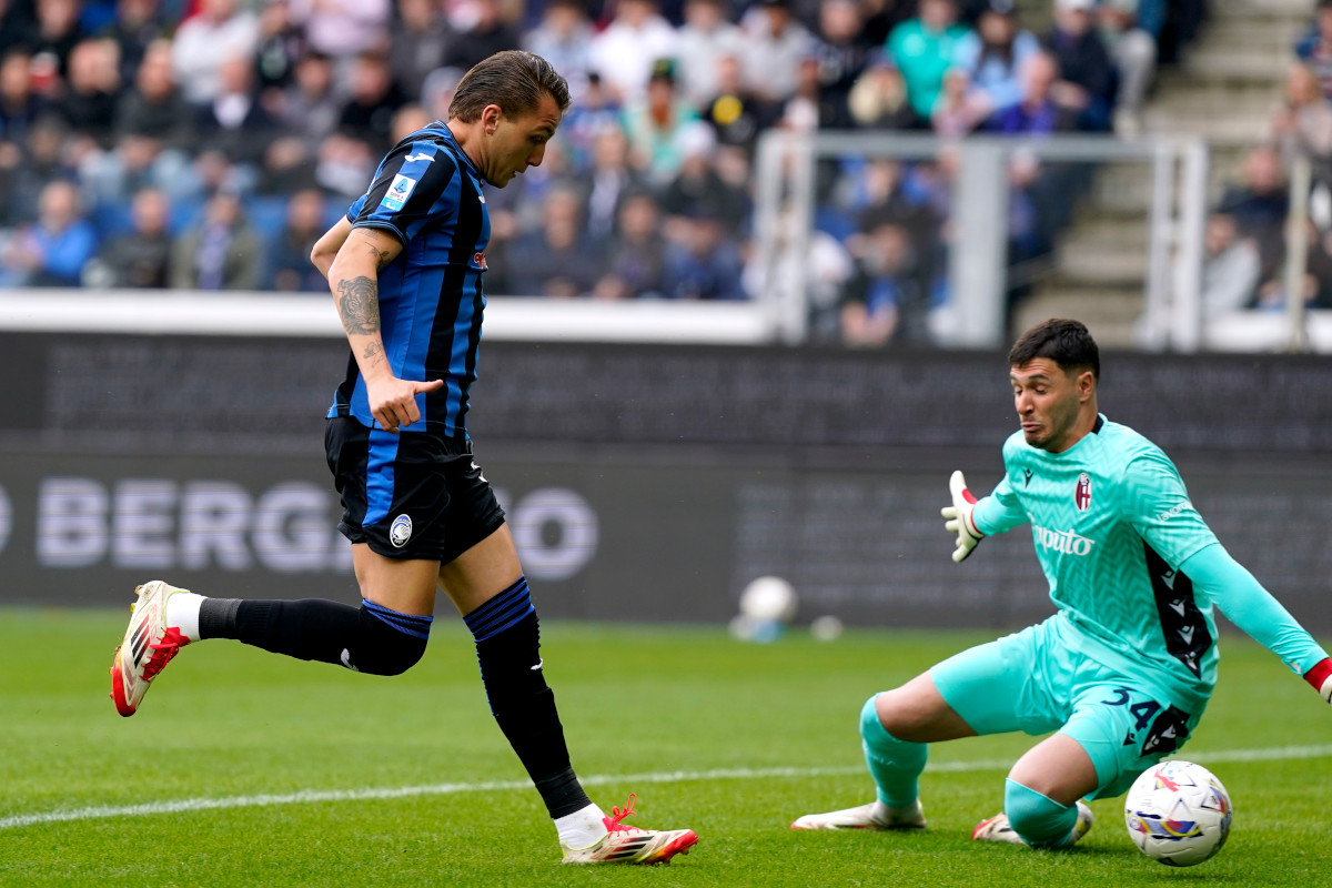 BERGAMO, ITALY - APRIL 13: Mateo Retegui of Atalanta scores his team's first goal past Federico Ravaglia of Bologna during the Serie A match between Atalanta and Bologna at Gewiss Stadium on April 13, 2025 in Bergamo, Italy. (Photo by Pier Marco Tacca/Getty Images)