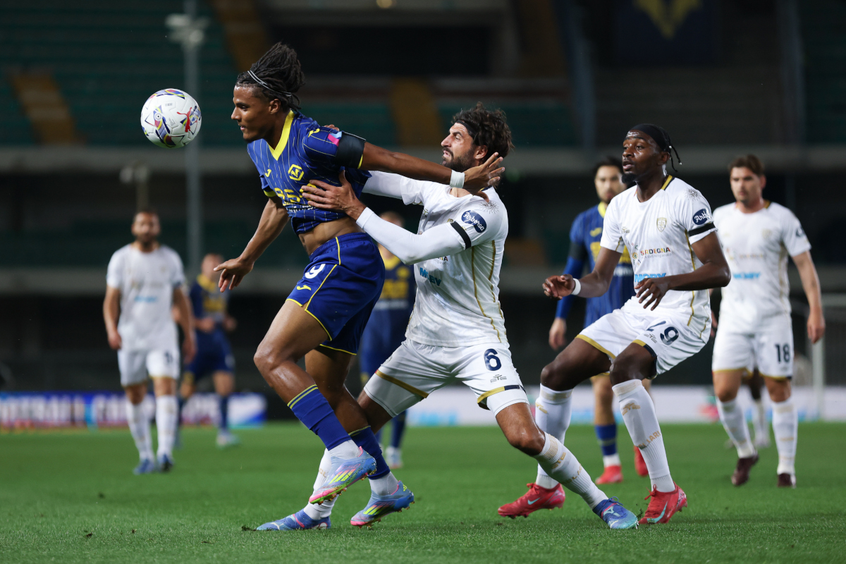 VERONA, ITALY - APRIL 28: Amin Sarr of Verona tries to control the ball under pressure from Sebastiano Luperto of Cagliari during the Serie A match between Verona and Cagliari at Stadio Marcantonio Bentegodi on April 28, 2025 in Verona, Italy. (Photo by Timothy Rogers/Getty Images)