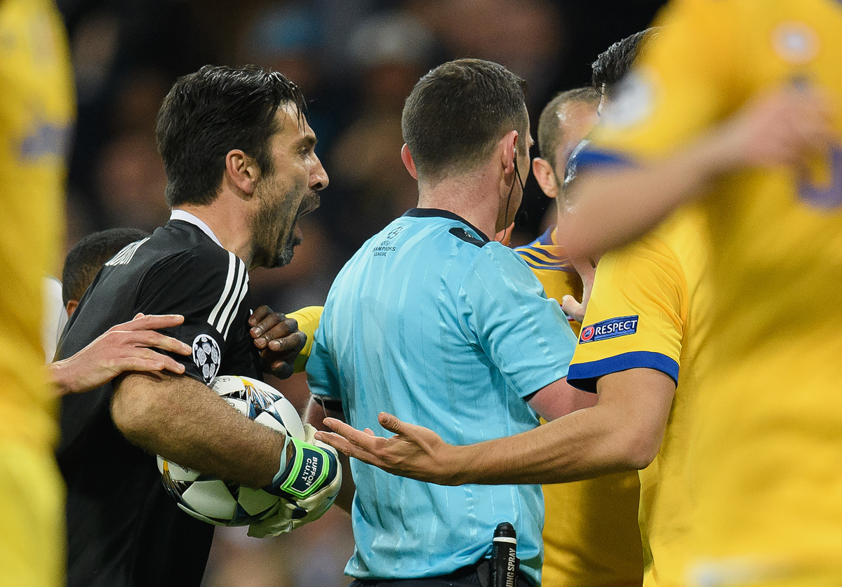 MADRID, ESPAÑA - 11 DE ABRIL DE 2018: Gianluigi Buffon de la Juventus se enfrenta al árbitro Michael Oliver después de que este concediera un penalti al Real Madrid durante el partido de vuelta de cuartos de final de la UEFA Champions League entre el Real Madrid y la Juventus en el Estadio Santiago Bernabéu el 11 de abril de 2018 en Madrid, España. (Foto de Matthias Hangst/Bongarts/Getty Images)