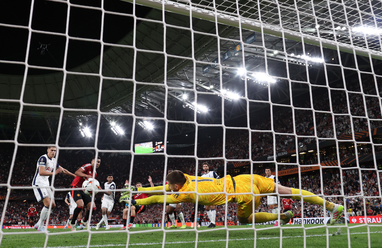 BILBAO, SPAIN - MAY 21: (EDITOR'S NOTE: Image was captured using a remote camera from behind the goal.) Guglielmo Vicario of Tottenham Hotspur saves a header from Luke Shaw of Manchester United as Micky van de Ven of Tottenham Hotspur and Casemiro of Manchester United look on during the UEFA Europa League Final 2025 between Tottenham Hotspur and Manchester United at Estadio de San Mames on May 21, 2025 in Bilbao, Spain. (Photo by Ryan Pierse/Getty Images)
