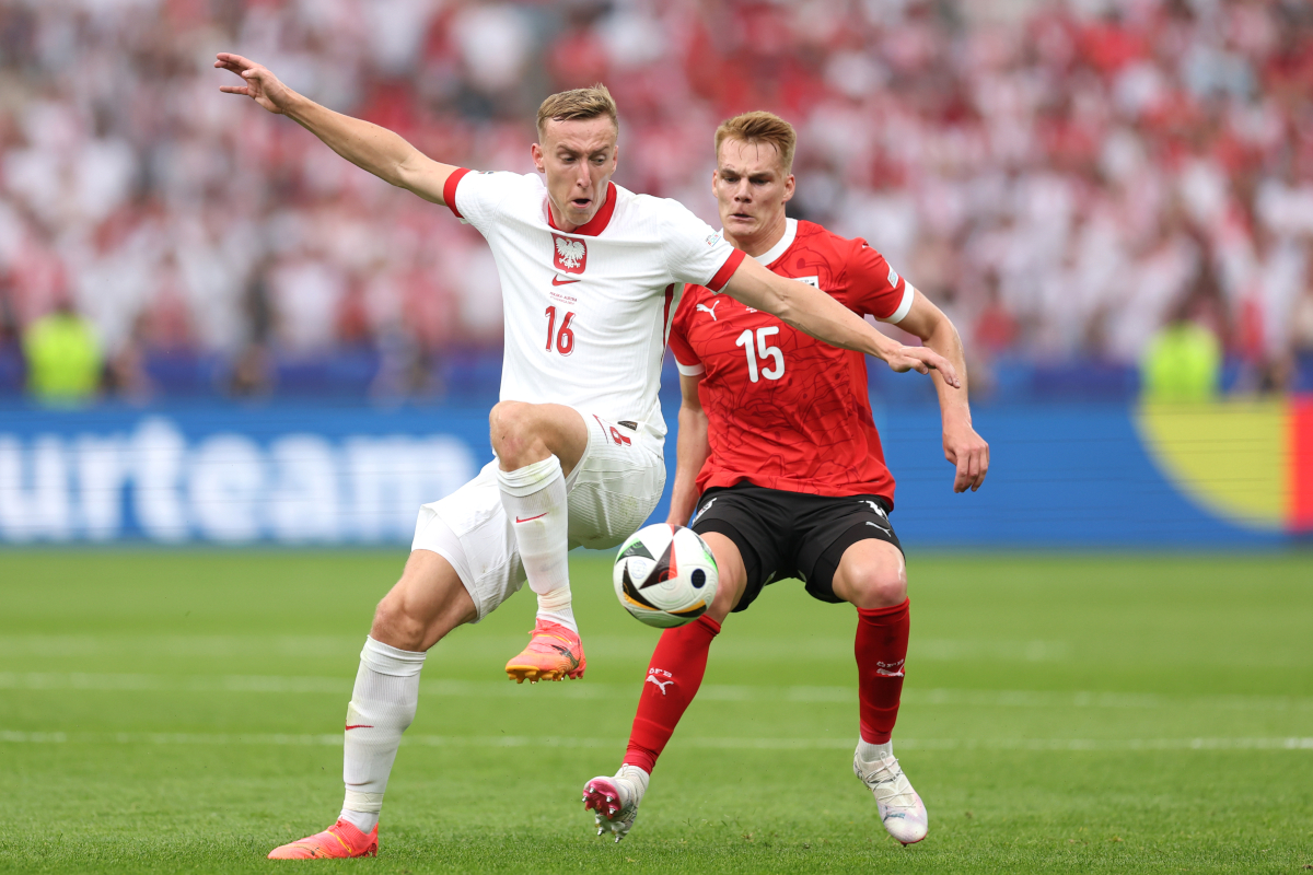 BERLIN, GERMANY - JUNE 21: Adam Buksa of Poland and Philipp Lienhart of Austria battle for possession during the UEFA EURO 2024 group stage match between Poland and Austria at Olympiastadion on June 21, 2024 in Berlin, Germany. (Photo by Julian Finney/Getty Images)
