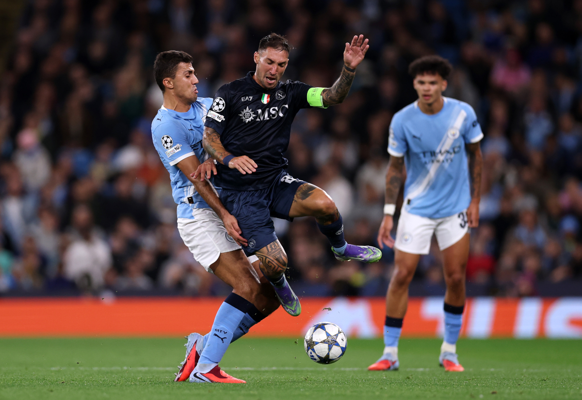 MANCHESTER, ENGLAND - SEPTEMBER 18: Matteo Politano of Napoli is challenged by Rodri of Manchester City during the UEFA Champions League 2025/26 League Phase MD1 match between Manchester City and SSC Napoli at City of Manchester Stadium on September 18, 2025 in Manchester, England. (Photo by Ryan Pierse/Getty Images)