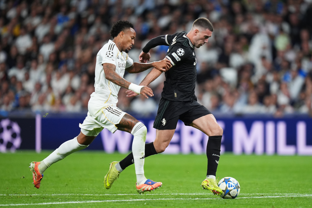 MADRID, SPAIN - OCTOBER 22: Dusan Vlahovic of Juventus runs with the ball whilst under pressure from Eder Militao of Real Madrid during the UEFA Champions League 2025/26 League Phase MD3 match between Real Madrid C.F. and Juventus at Estadio Santiago Bernabeu on October 22, 2025 in Madrid, Spain. (Photo by Angel Martinez/Getty Images)