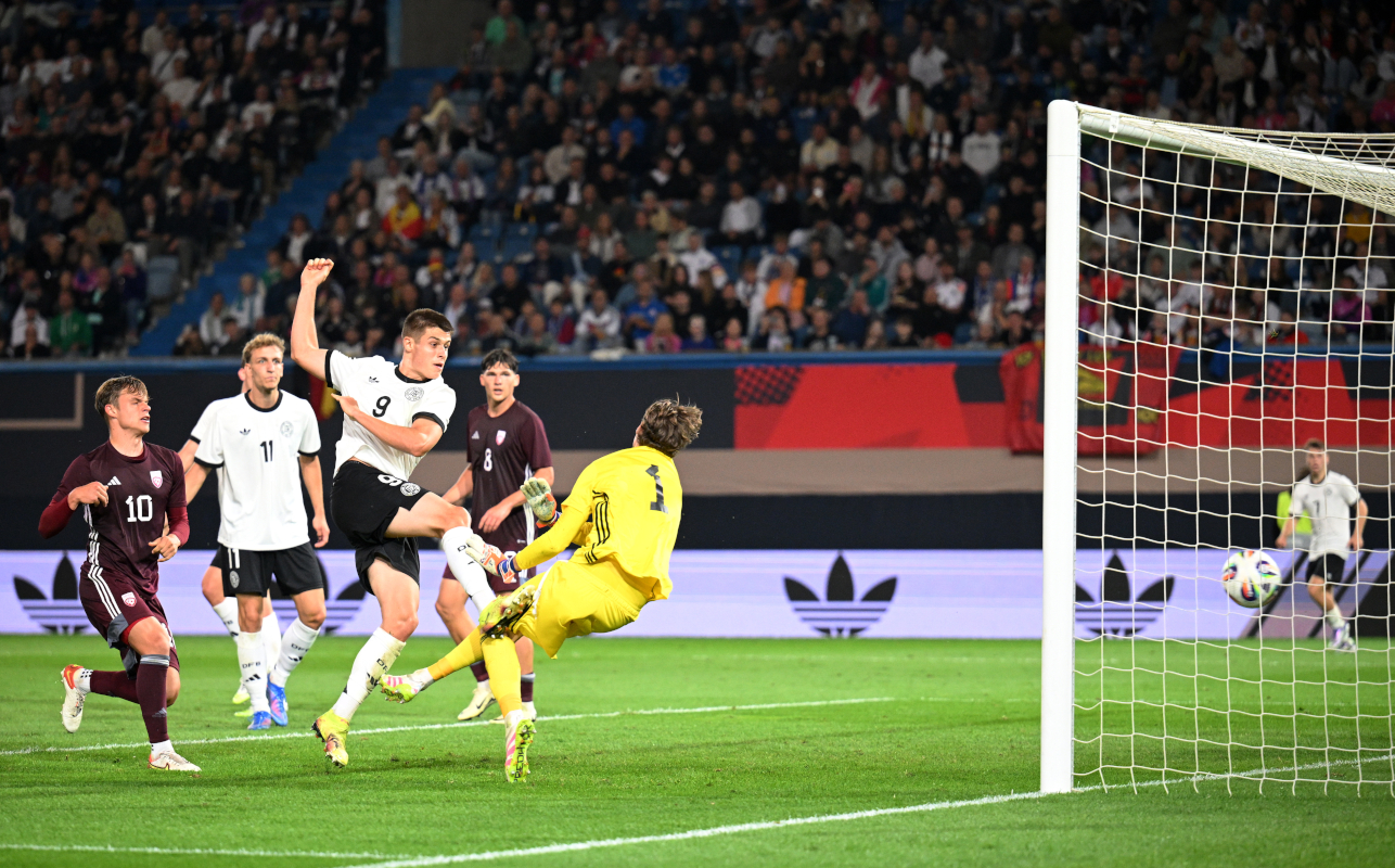 ROSTOCK, GERMANY - SEPTEMBER 09: Nicolo Tresoldi of Germany scores his team's fourth goal past Nikita Parfjonovs of Latvia during the  2025 UEFA European Under-21 Championship Qualifier match between Germany U21 and Latvia U21 at Ostseestadion on September 09, 2025 in Rostock, Germany.  (Photo by Stuart Franklin/Getty Images)