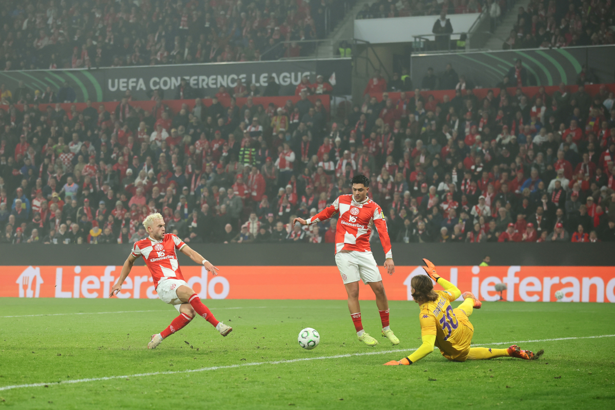 MAINZ, GERMANY - NOVEMBER 06: Benedict Hollerbach of 1.FSV Mainz 05 scores his team's first goal past Tommaso Martinelli of Fiorentina during the UEFA Conference League 2025/26 League Phase MD3 match between 1. FSV Mainz 05 and ACF Fiorentina at Mainz Arena on November 06, 2025 in Mainz, Germany. (Photo by Alex Grimm/Getty Images)