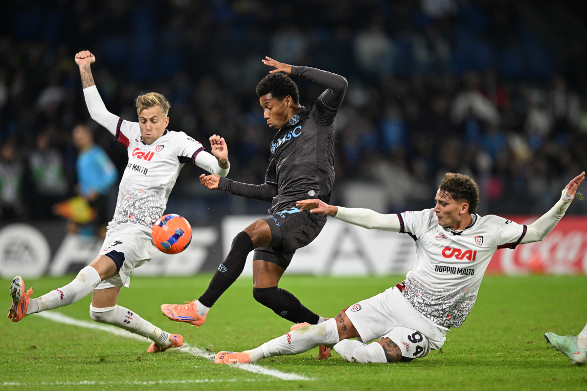 NAPLES, ITALY - DECEMBER 03: David Neres of SSC Napoli is challenged by Mattia Felici and Sebastiano Esposito of Cagliari during the Coppa Italia round of 16 match between SCC Napoli and Cagliari Calcio at Stadio Diego Armando Maradona on December 03, 2025 in Naples, Italy. (Photo by Francesco Pecoraro/Getty Images)