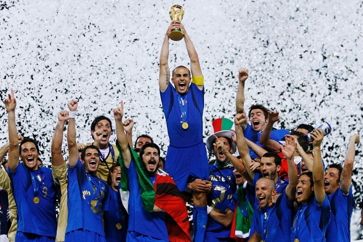 BERLIN - JULY 09: The Italian players celebrate as Fabio Cannavaro of Italy lifts the World Cup trophy aloft following victory in a penalty shootout at the end of the FIFA World Cup Germany 2006 Final match between Italy and France at the Olympic Stadium on July 9, 2006 in Berlin, Germany. (Photo by Shaun Botterill/Getty Images)