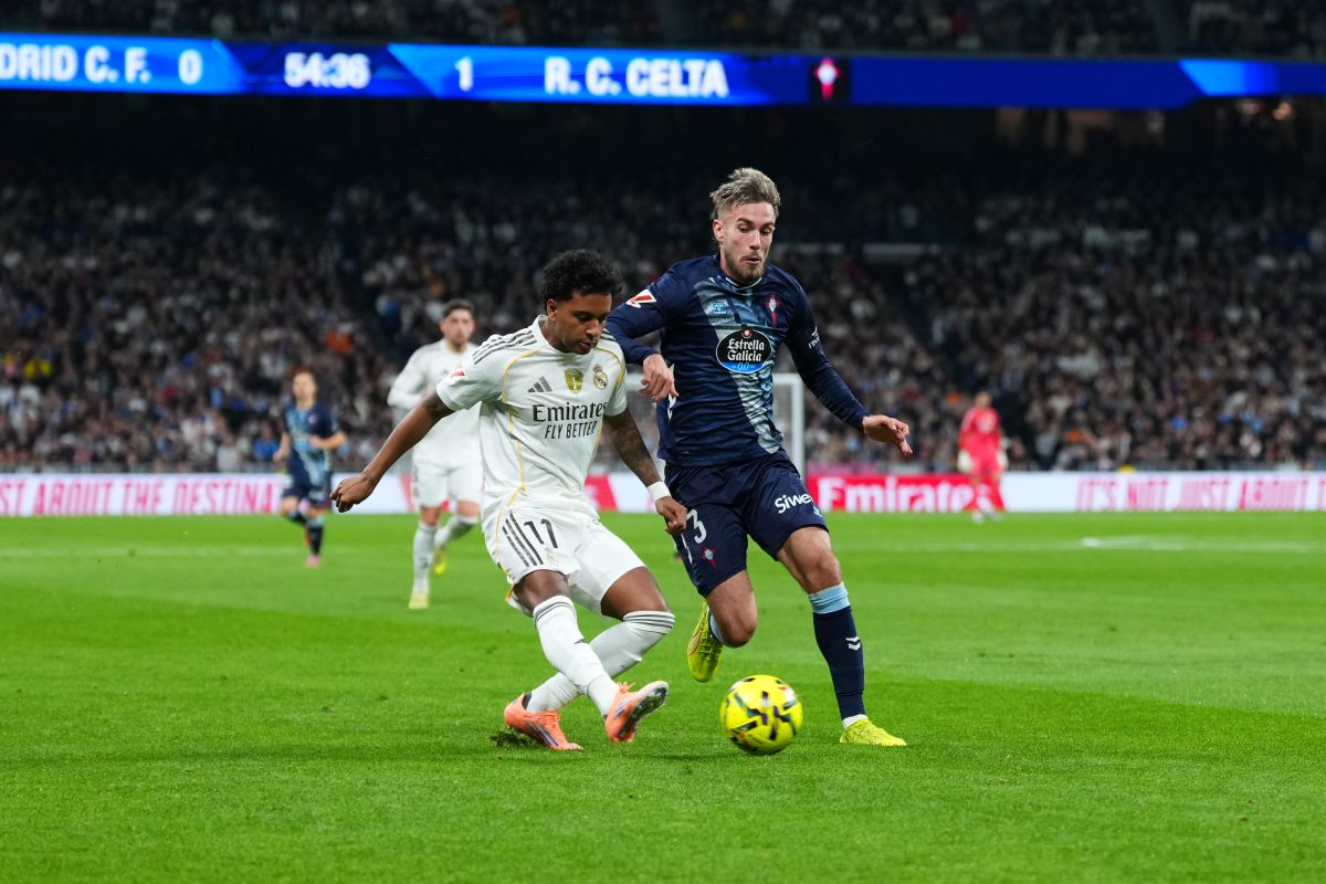 MADRID, SPAIN - DECEMBER 07: Rodrygo of Real Madrid crosses the ball whilst under pressure from Oscar Mingueza of Celta Vigo during the LaLiga EA Sports match between Real Madrid CF and RC Celta de Vigo at Estadio Santiago Bernabeu on December 07, 2025 in Madrid, Spain. (Photo by Angel Martinez/Getty Images)