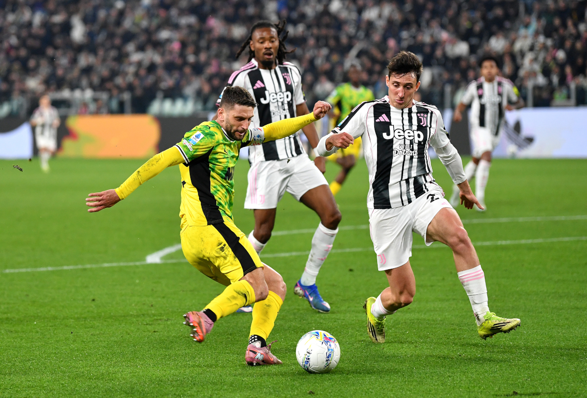 TURIN, ITALY - MARCH 21: Domenico Berardi of US Sassuolo Calcio crosses the ball whilst under pressure from Andrea Cambiaso of Juventus during the Serie A match between Juventus FC and US Sassuolo Calcio at Allianz Stadium on March 21, 2026 in Turin, Italy. (Photo by Valerio Pennicino/Getty Images)