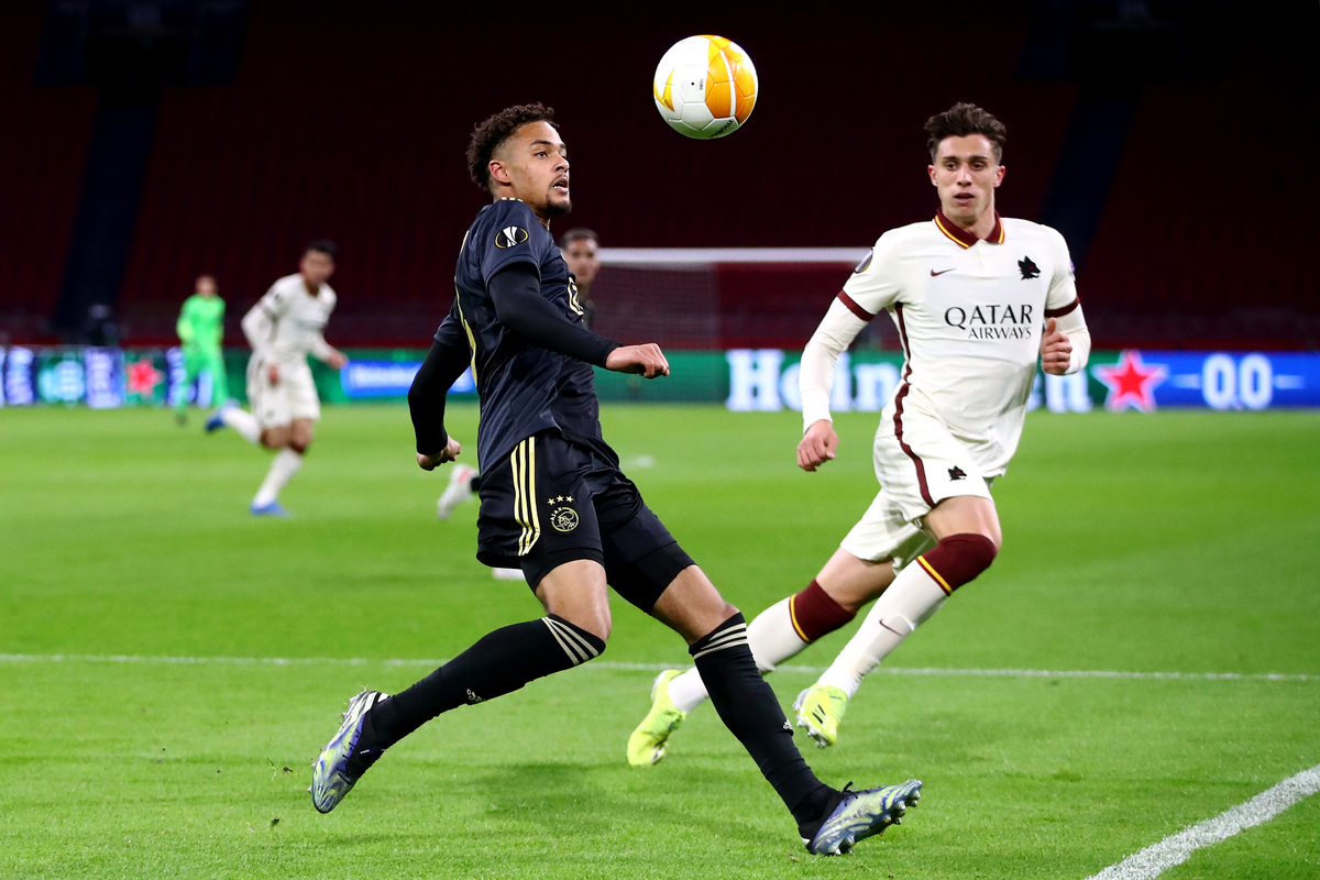AMSTERDAM, NETHERLANDS - APRIL 08:  Riccardo Calafiori of Roma battles for the ball with Devyne Rensch of Ajax during the UEFA Europa League Quarter Final First Leg match between Ajax and AS Roma at Johan Cruijff Arena on April 08, 2021 in Amsterdam, Netherlands. Sporting stadiums around Europe remain under strict restrictions due to the Coronavirus Pandemic as Government social distancing laws prohibit fans inside venues resulting in games being played behind closed doors. (Photo by Dean Mouhtaropoulos/Getty Images)