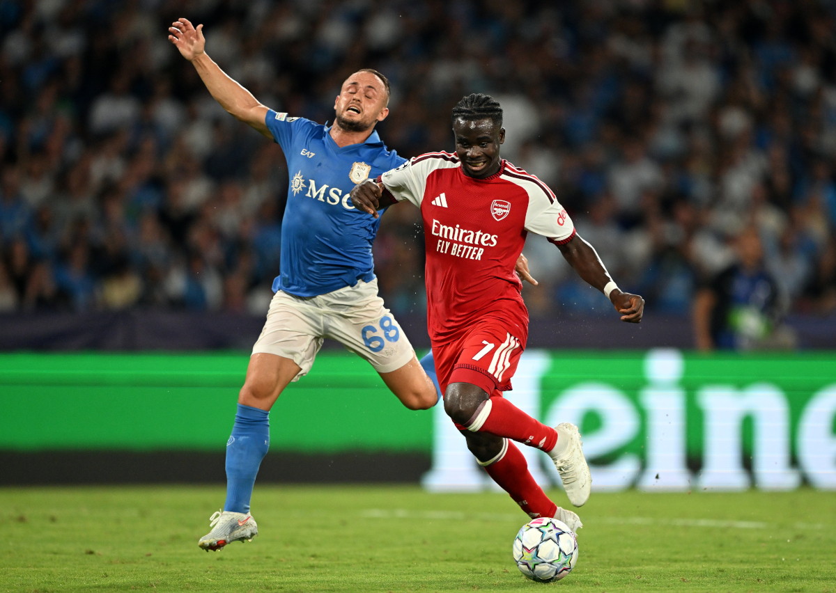 NÁPOLES, ITÁLIA - 09 DE SETEMBRO: Bugayo Saka, do Arsenal, corre com a bola sob pressão de Stanislav Lobotka, do SSC Napoli, durante a partida da Fase MD1 da Liga dos Campeões da UEFA 2026/27 entre SSC Napoli e Arsenal FC. (Foto: Francesco Pecoraro/Getty Images)