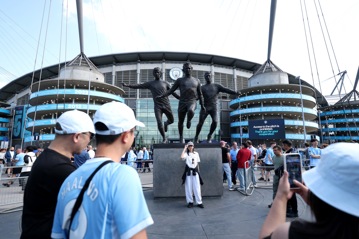 MANCHESTER, INGLATERRA - 23 DE AGOSTO: Manchester, Inglaterra - 23 de agosto: Uma vista geral fora do estádio enquanto os torcedores posam perto da estátua de Colin Bell, Francis Lee e Mike Summerbee antes da partida da Premier League 2026/27 entre Manchester City e AFC Bournemouth. (Foto de Michael Steele/Getty Images)