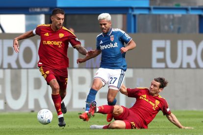 ITALY - OCTOBER 11: Yan Couto of Como 1907 is tackled by Marten de Roon and Lorenzo Pellegrini of AS Roma during the Serie A match between Como 1907 and AS Roma at Giuseppe Sinigaglia Stadium on October 11, 2026 in Italy. (Photo by Marco Luzzani/Getty Images)